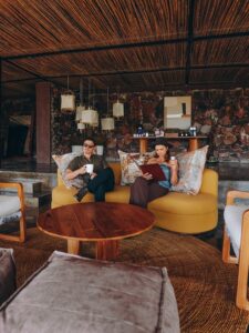 Couple relaxing at a luxury safari lodge lounge during a honeymoon in Tanzania, enjoying a peaceful and romantic setting