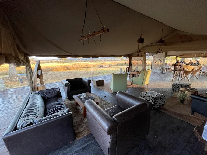 Luxury safari lodge interior in Tanzania with seating and scenic savannah view