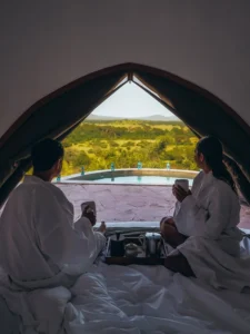 Couple enjoying honeymoon safari in Serengeti with scenic view from luxury tent