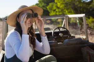 First-time safari traveler using binoculars during Serengeti safari in Tanzania